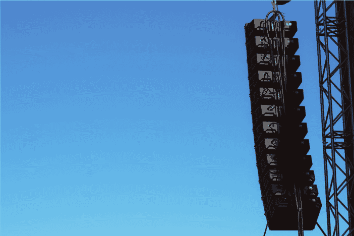 Outdoor speaker setup with visible speaker audio cables connecting a professional sound system, ensuring high-quality audio transmission for live events