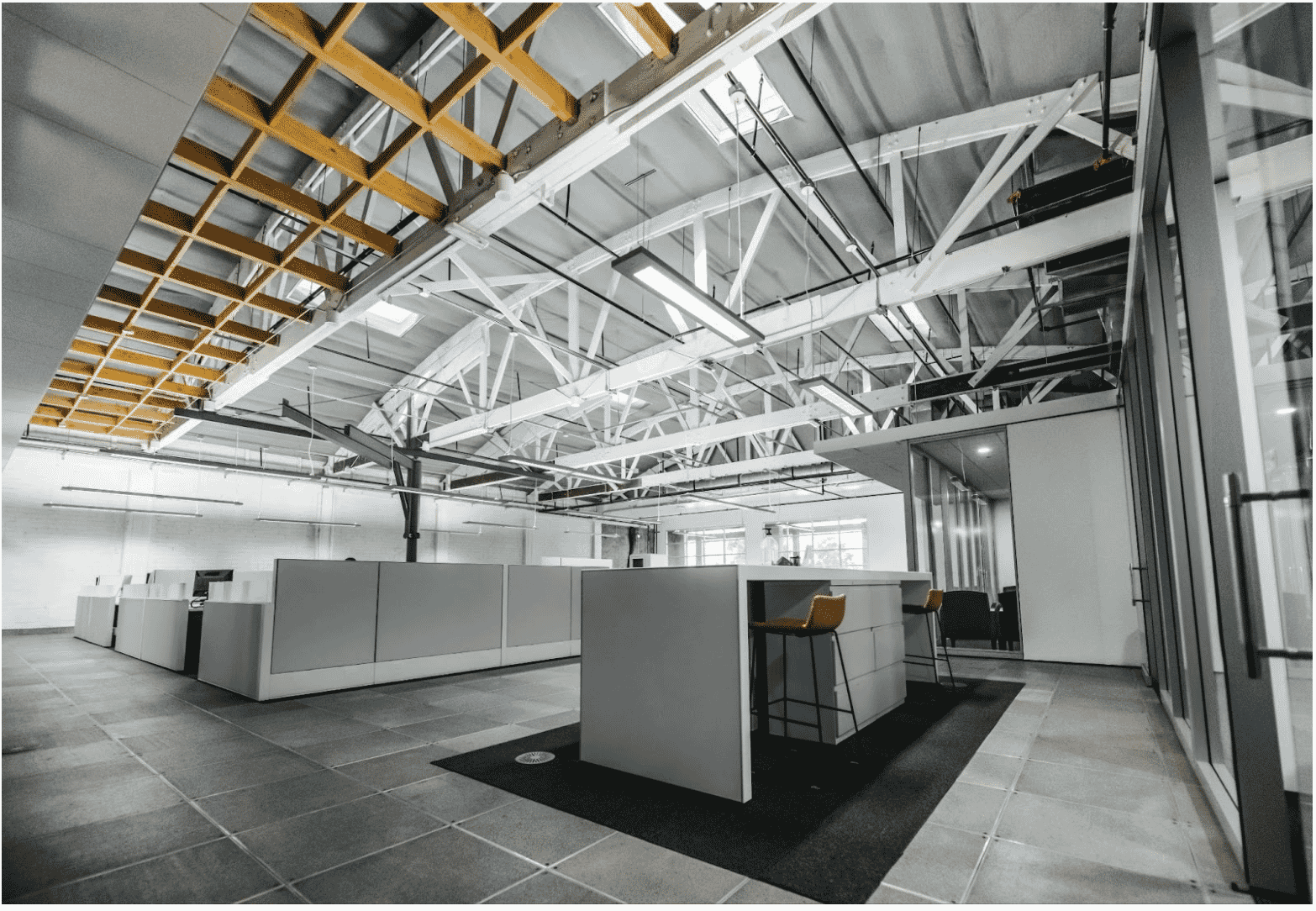 A modern office space with sleek glass-walled meeting rooms, showcasing the role of smart building wiring in powering efficient and connected commercial environments