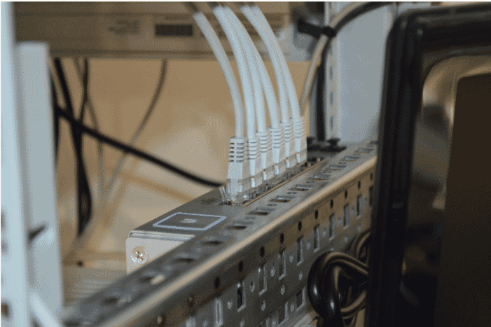 Close-up of digital media cables connected to a network switch, highlighting their role in efficient and reliable data transmission for modern media systems
