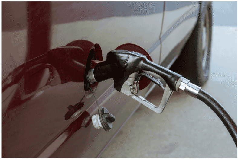 Fuel pump nozzle inserted into a vehicle, highlighting the importance of petroleum-proof industrial cables for safe and efficient fuel transfer operations