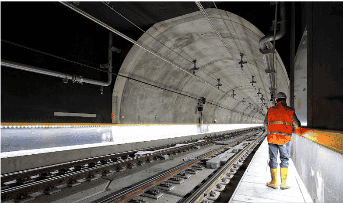Construction worker inspecting a modern underground tunnel equipped with long-lasting building wire for reliable and durable electrical infrastructure